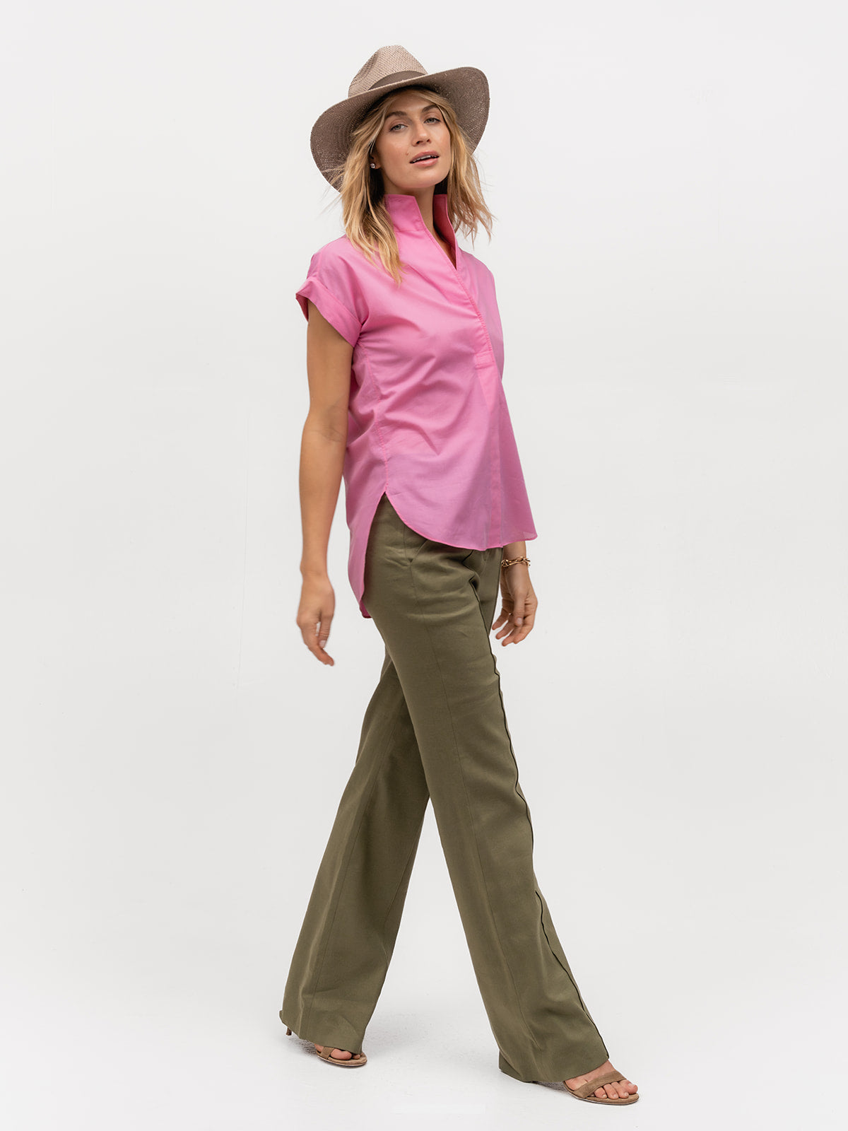 Woman walking and wearing a hot pink short sleeve luxury top